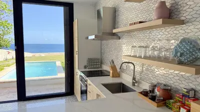 a kitchen with a sink and a swimming pool at Tesoro Villas in Río San Juan