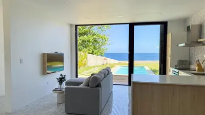 a kitchen and living room with a view of the ocean at Tesoro Villas in Río San Juan