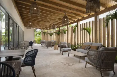 a patio with chairs and couches and tables at Royal Beach Hotel Punta Cana, A JdV by Hyatt in Punta Cana