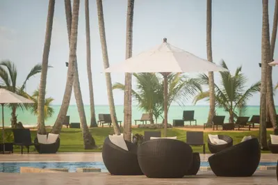 a resort with chairs and palm trees and the ocean at Coson Bay in Las Terrenas