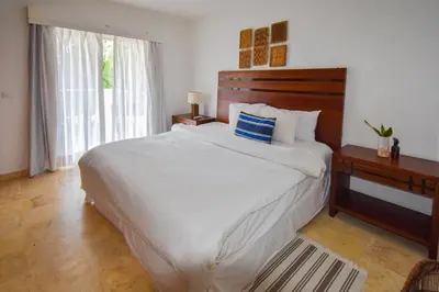 a bedroom with a large white bed and a window at Coson Bay in Las Terrenas