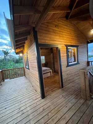 a wooden house with a large wooden deck at Villas Gabriel in Nagua