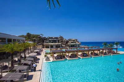 a pool at a resort with chairs and the ocean at Modern 3 BR Villa with pool in gated community in Sosúa