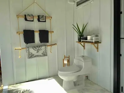 a bathroom with a white toilet and towels at JAVO BEACH the Nest in Las Galeras