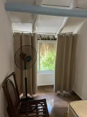 a room with a fan and a window at The Coco Garden Cabin in Las Galeras