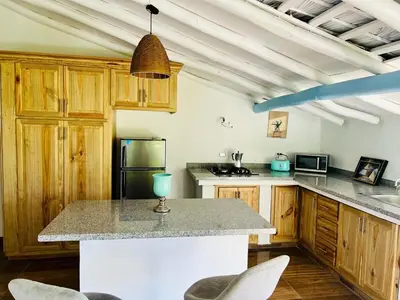 a kitchen with wooden cabinets and a large counter top at The Coco Garden Cabin in Las Galeras