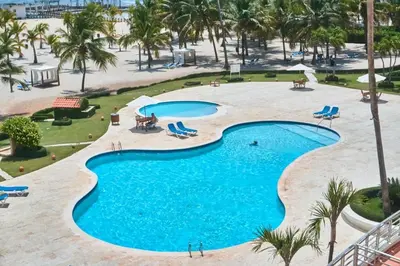 an overhead view of a pool at a resort at Escape Beachfront Condo Costa del Sol Juan Dolio in Los Corrales