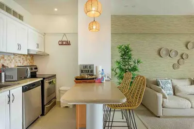 a kitchen with a table and a couch in a room at Escape Beachfront Condo Costa del Sol Juan Dolio in Los Corrales