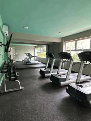 a gym with several rows of tread machines in a room at Apartamento Tipo resort-style space in Santiago de los Caballeros