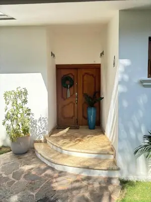 a front door of a house with two potted plants at Casa de Campo Golf, Villa La Romana in La Romana