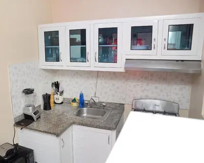 a kitchen with white cabinets and a sink at HERMOS APARTAMENTo in Santiago de los Caballeros