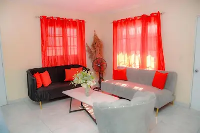 a living room with two couches and red curtains at HERMOS APARTAMENTo in Santiago de los Caballeros