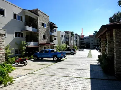 a blue truck parked in a parking lot next to buildings at Luxury Apartment close to centre of Jarabacoa in Jarabacoa