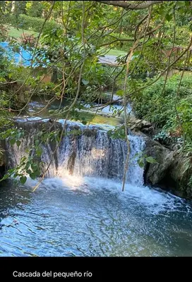 a stream of water with a waterfall in a forest at villas bahia in Sánchez
