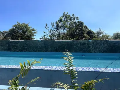 a retaining wall next to a blue swimming pool at Habitacion 2 en Dani's Guest House in Las Galeras