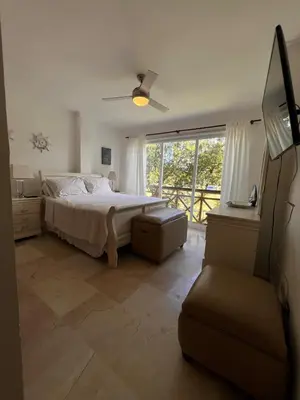a bedroom with a bed and a large window at Beautiful apartment in Playa Dorada in San Felipe de Puerto Plata