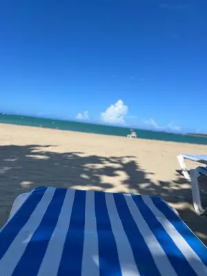 a blue and white striped mattress on the beach at Beautiful apartment in Playa Dorada in San Felipe de Puerto Plata
