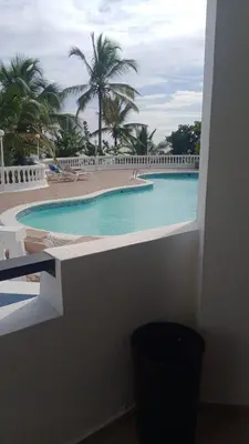 a view of a swimming pool with palm trees at Costa Azul Skibel 2 br in Santo Domingo