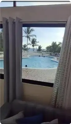 a window with a view of a swimming pool at Costa Azul Skibel 2 br in Santo Domingo