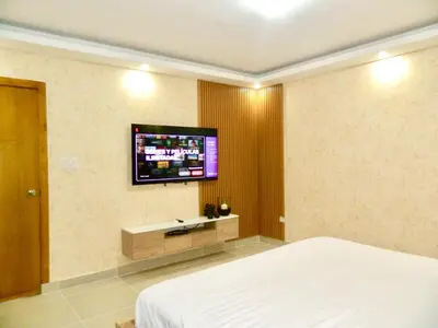 a bedroom with a bed and a flat screen tv on the wall at The Chic Hideout full apt in san isidro Terrace in Juan López
