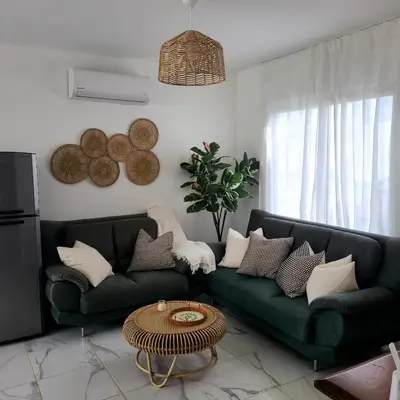 a living room with two green couches and a table at Villa con piscina privada en Punta Cana in Punta Cana