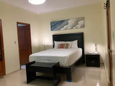 a bedroom with a large bed and a table at Residencial Don Pedro 1103 in Santo Domingo