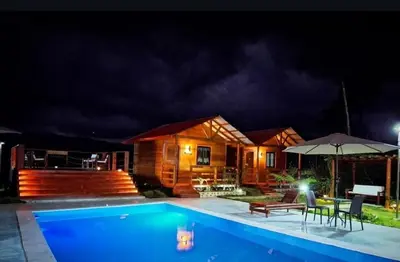 a house with a swimming pool at night at Ecocamping Aventura in Boca de Cana
