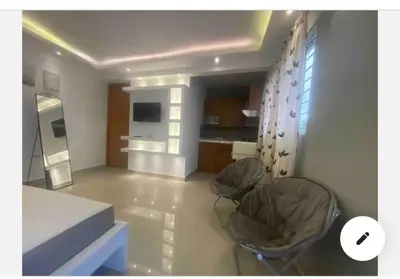 a living room with two chairs and a kitchen at Casa con jacuzzi in Santiago de los Caballeros