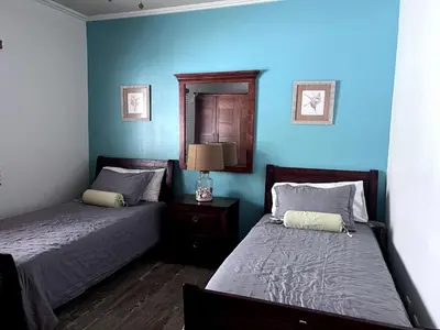 two beds in a bedroom with blue walls at Jojo's Caribbean Retreat in Punta Cana