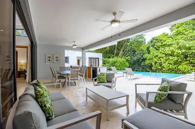 a living room with a couch and chairs and a pool at Casa Linda Villa 767 - Sosua in Sosúa