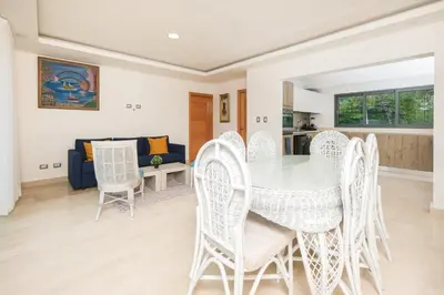 a dining room and living room with a table and chairs at Amare Residences - Beachfront complex in Las Terrenas