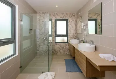 a bathroom with two sinks and a glass shower at Amare Residences - Beachfront complex in Las Terrenas