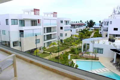 an apartment balcony with a view of a swimming pool at Amare Residences - Beachfront complex in Las Terrenas
