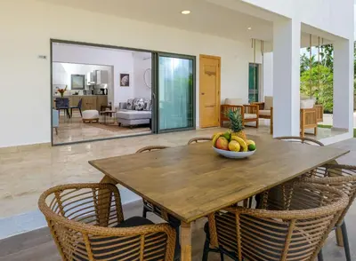 a dining room with a wooden table with a bowl of fruit on it at Amare Residences - Beachfront complex in Las Terrenas