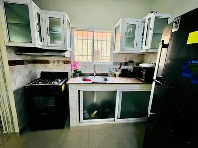 a kitchen with white cabinets and a black refrigerator at Oasis de Paz 04 in Colorado