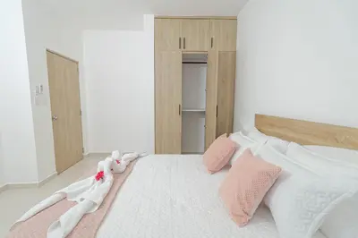 a bedroom with a bed with pink and white pillows at Modern 1BR Retreat Central Bayahibe Sunshine in San Rafael del Yuma