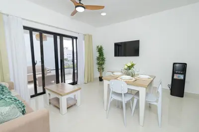 a living room with a dining room table with chairs and a television at Modern 1BR Retreat Central Bayahibe Sunshine in San Rafael del Yuma