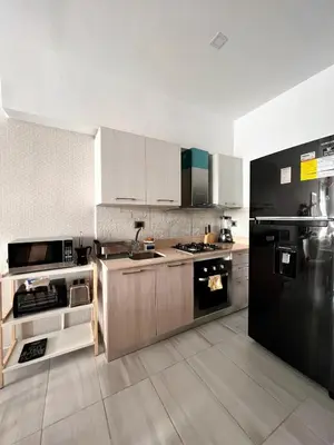 a kitchen with white cabinets and a black refrigerator at Comodo departamento centrico SD in Santo Domingo