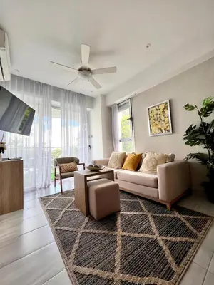 a living room with a couch and a ceiling fan at Comodo departamento centrico SD in Santo Domingo