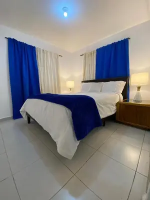 a bedroom with a large bed with blue curtains at Ideal with a Jacuzzi, pool in Colorado