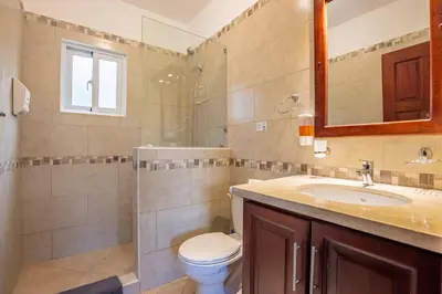 a bathroom with a toilet and a sink and a mirror at Casa Linda Villa 722 - Sosua - BBQ - Washer in Sosúa