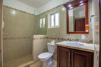 a bathroom with a toilet and a sink and a mirror at Casa Linda Villa 722 - Sosua - BBQ - Washer in Sosúa