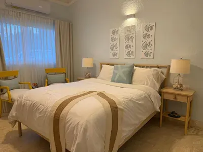 a bedroom with a large bed and two chairs at Juan Dolio House 2BR y Patio in Los Corrales