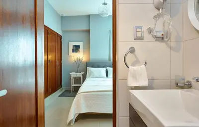 a bedroom with a bed and a bathroom with a sink at YOUR SPACE IN SANTO DOMINGO Gazcue in Colorado