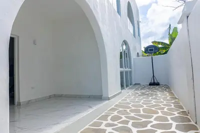 a hallway of a white building with a stone floor at Grecialandia in San Felipe de Puerto Plata
