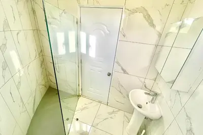 a white bathroom with a sink and a shower at Grecialandia in San Felipe de Puerto Plata