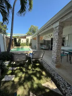 two chairs sitting in front of a swimming pool at 2BR Juan Dolió House in Juan Dolio