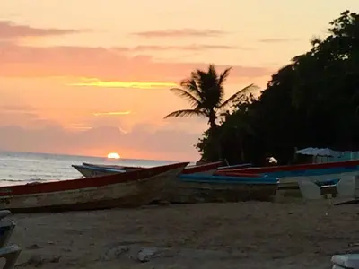 a group of boats sitting on the beach at sunset at 2BR Juan Dolió House in Juan Dolio
