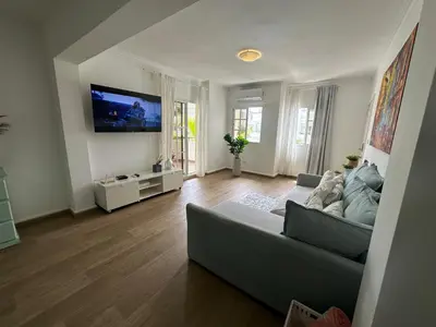 a living room with a couch and a flat screen tv at The best place to rest, Arenas del Caribe in Punta Cana