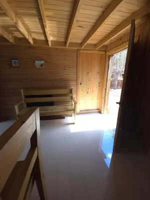 a room with a bench in a wooden cabin at La Casita De La Cueva in Cabo Rojo
